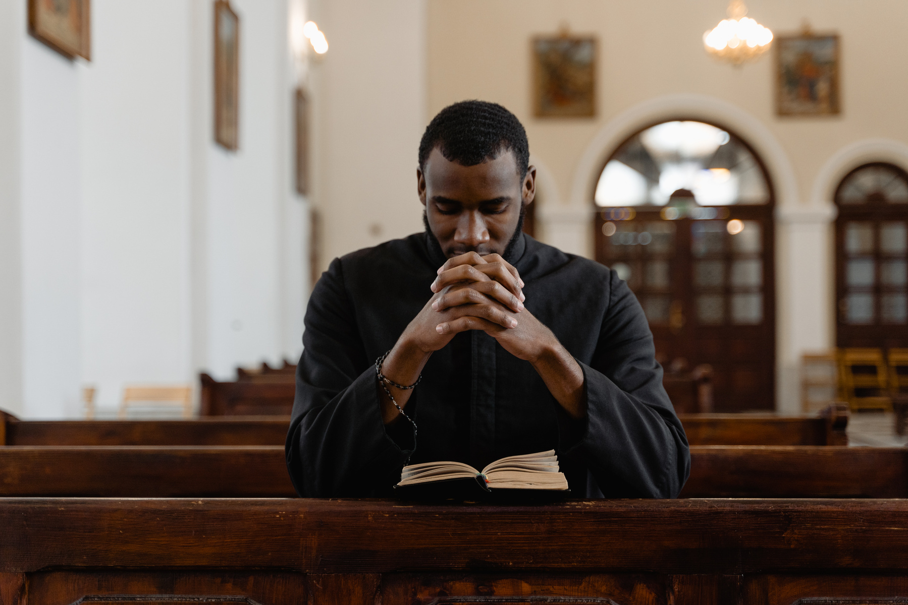 A Priest in Black Vestment Praying